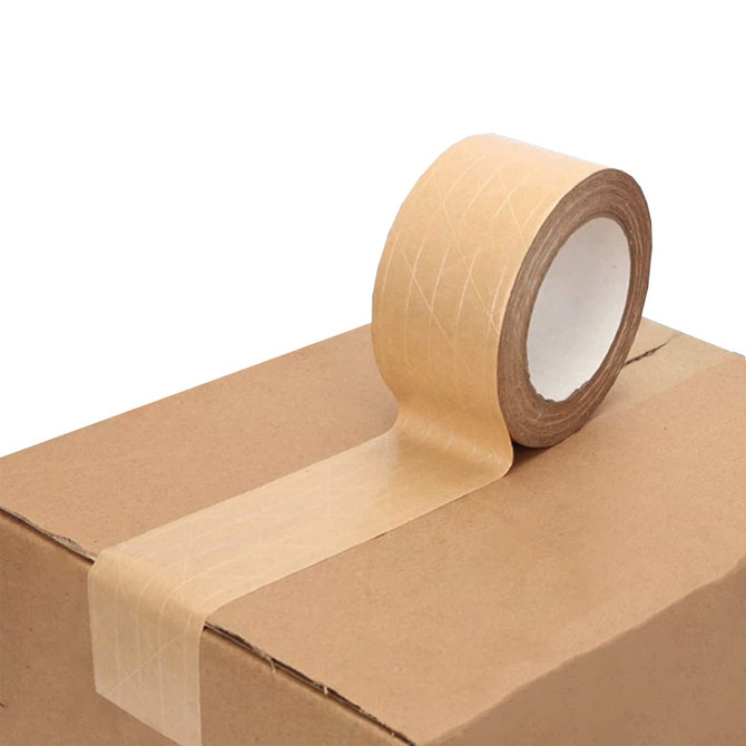 A roll of self-adhesive reinforced kraft paper tape in a natural brown hue, placed on a kraft cardboard box.