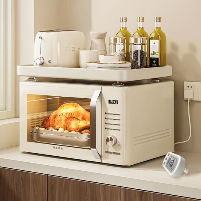A cream-coloured microwave oven sits on a counter, displaying a cooked chicken inside, with condiments and a toaster nearby.