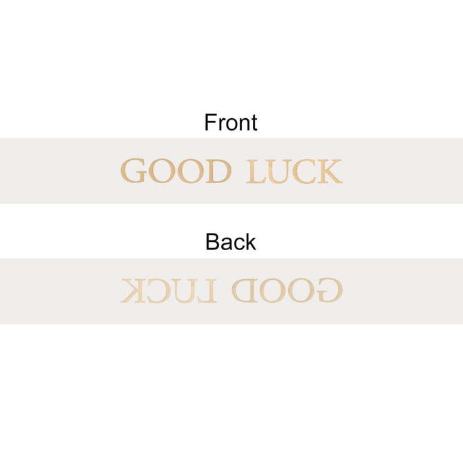 A soft ribbon in a light colour featuring the words "GOOD LUCK" printed on both sides. It has a simple branding logo.