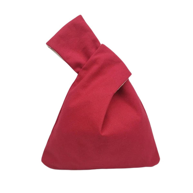 A red cotton wrist bag with a unique folded design, featuring a simple, casual appearance.