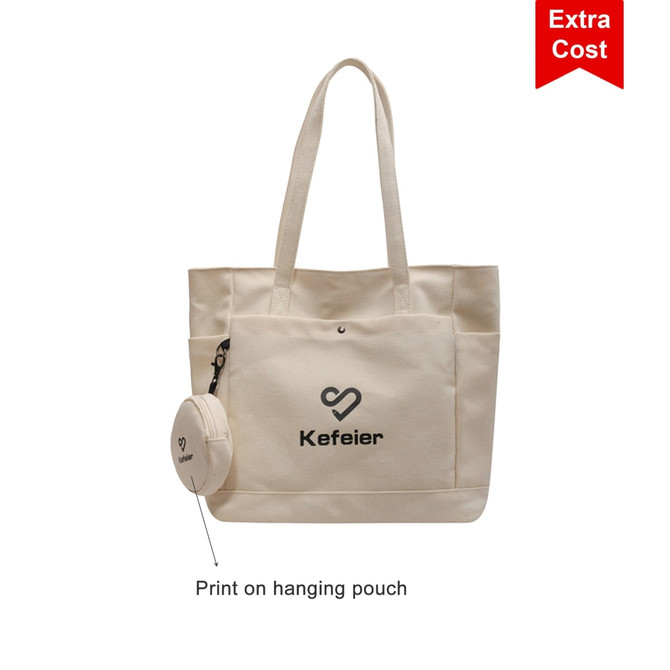 A cream canvas tote bag with long handles and a small attached pouch. It features a logo.