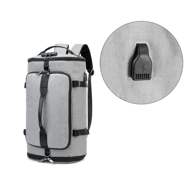 A grey convertible bucket backpack duffel bag with black straps and a circular detail showing the zipper pull.