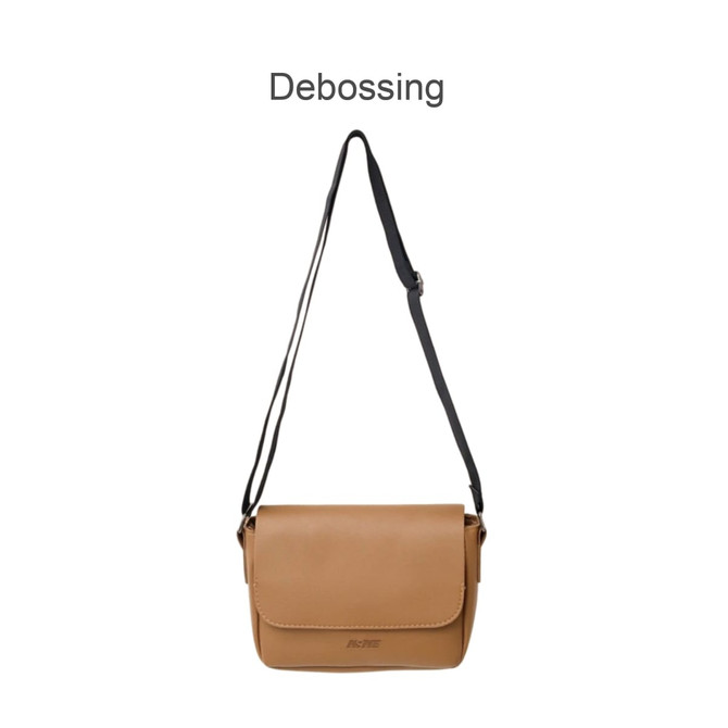 A tan polyurethane shoulder bag with a black strap, featuring a flap closure and a logo.
