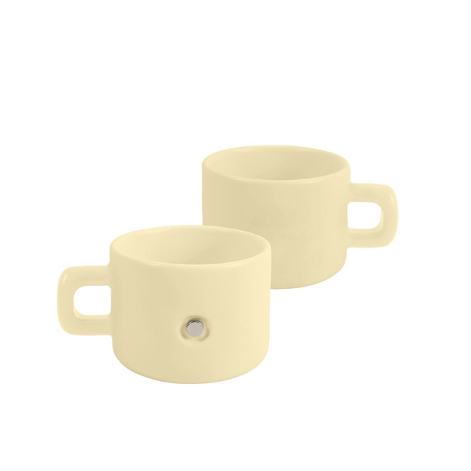 A cream-coloured ceramic mug with a magnetic feature and a handle, showcasing a sleek, minimalist design.