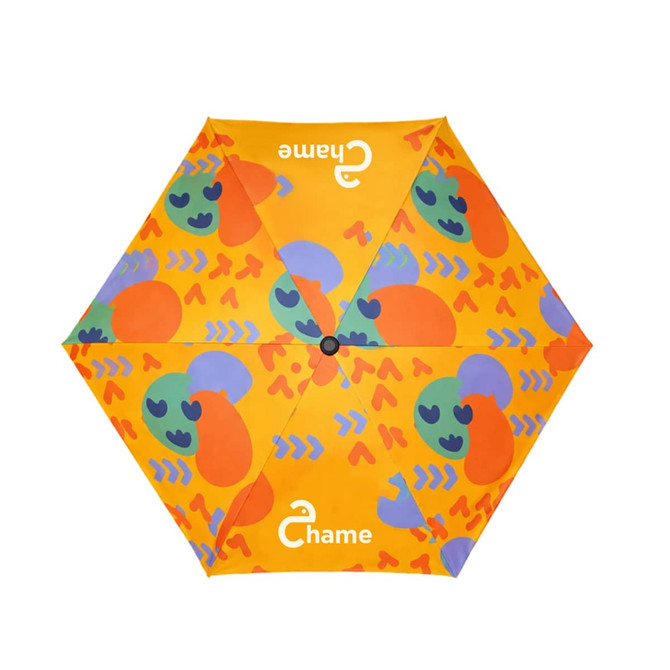 A small umbrella featuring a bright yellow canopy with vibrant orange and green abstract patterns, including a logo.