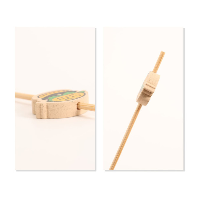 A bamboo skewer with a decorative wooden topper, featuring vibrant colours and a logo. Ideal for cocktail presentation.