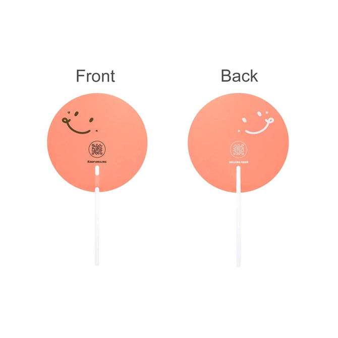 A transparent PVC hand fan in a round shape, featuring a pink-orange colour with smiley designs on both sides.