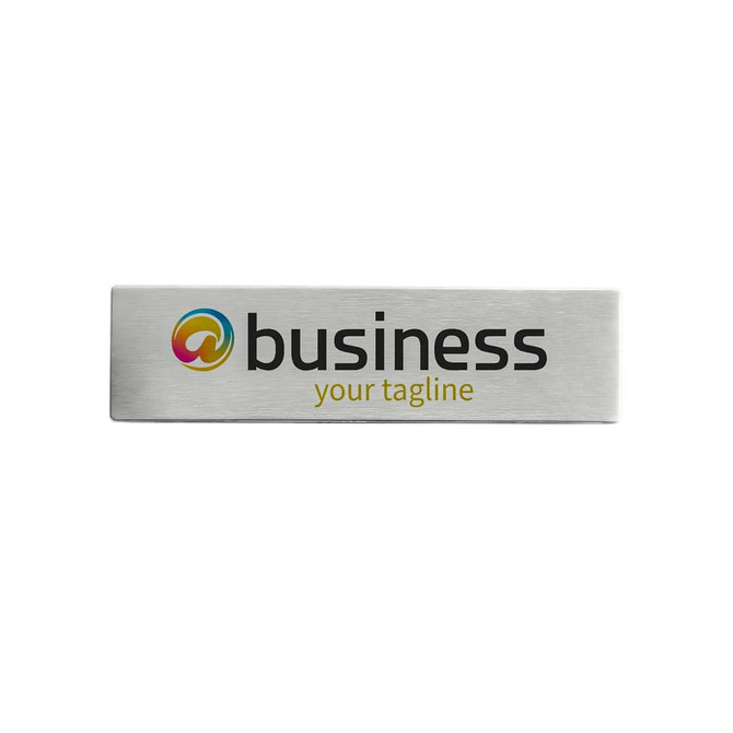A metal name badge featuring a silver finish with a logo and text.