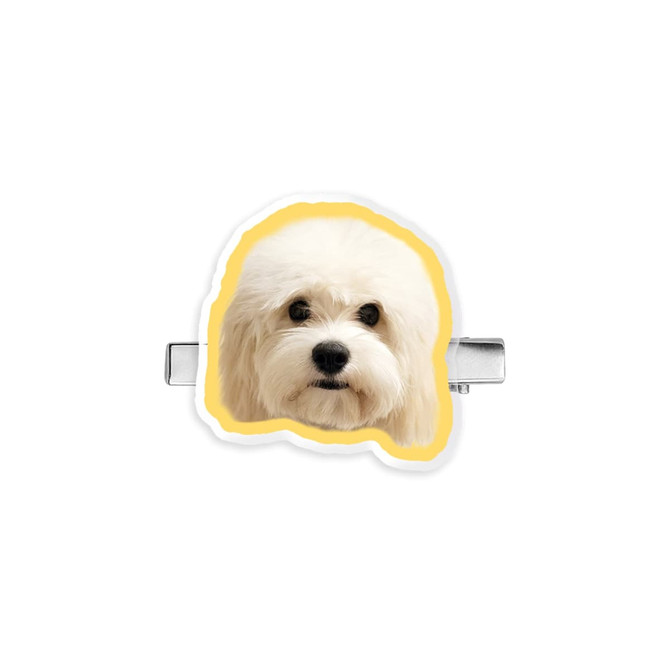 A custom-shaped acrylic hair clip featuring a fluffy white dog design with a yellow border. It has a metal clip on the back.