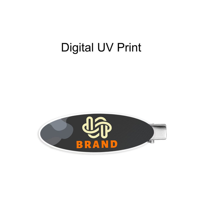 An oval acrylic hair clip featuring a dark design with a logo and vibrant colours.