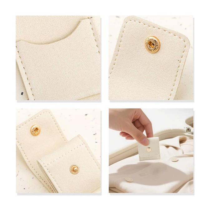 A mini synthetic leather jewellery bag in cream colour, featuring gold snap closures and interior compartments.