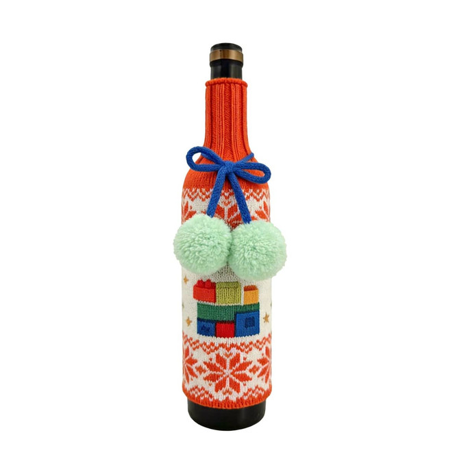 A drink bottle wrapped in a custom knitted sleeve featuring festive patterns, orange and white colours, and green pom-poms.