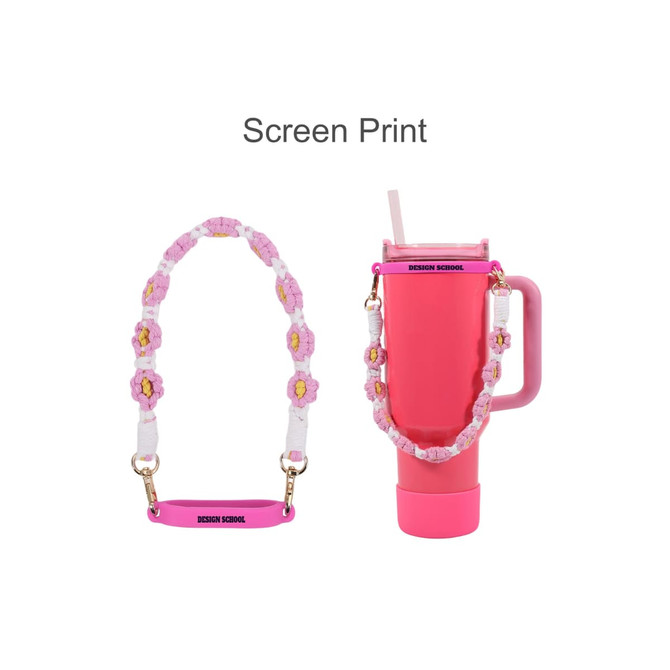A drink bottle with a pink and white woven strap featuring yellow flowers, along with a logo on the strap.