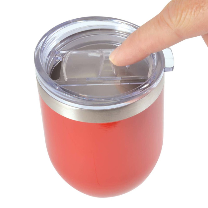 A reusable coffee cup in a vibrant red color with a silicone lid and a metallic band, featuring a finger pressing the lid.