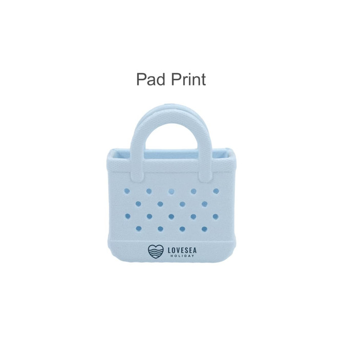 A light blue mini EVA bag charm with perforations and a handle, featuring a logo on the front.