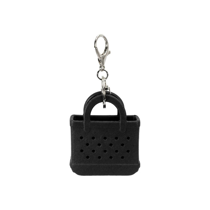 A black mini keychain shaped like a handbag, featuring holes and a metal clip for attachment.