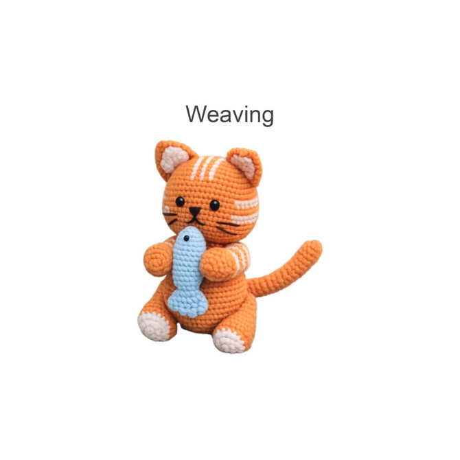 An orange crocheted cat holding a blue fish, featuring distinct stripes and a tail, against a light background.