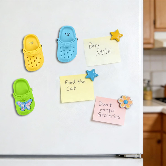 Classic clog shoe fridge magnets in blue and yellow, attached to a fridge with sticky notes and other magnets.