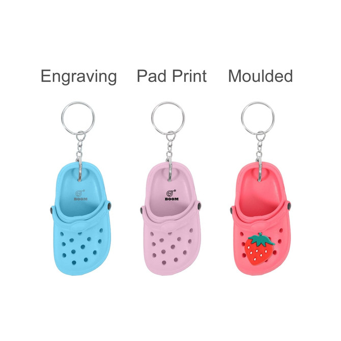 A keyring featuring classic clog shoes in blue, pink, and red with a strawberry design, each on a metal chain.