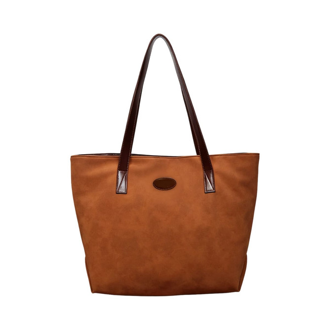 A brown suede leather tote bag with darker brown handles and a logo on the front.