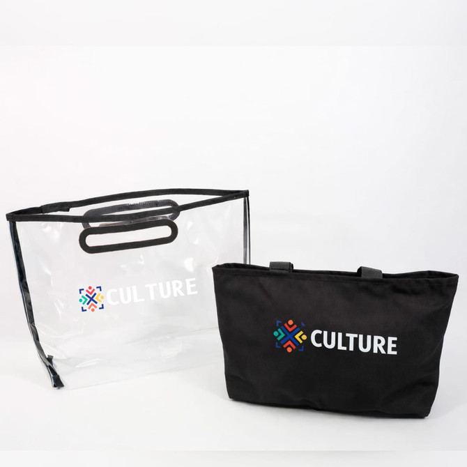 A black tote bag with handles next to a transparent PVC cover, both featuring a logo.