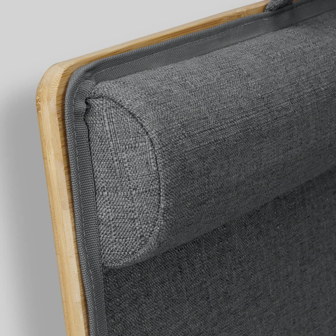 A bamboo lap desk features a grey padded fabric and rounded edges for comfort. It includes a logo on the side.