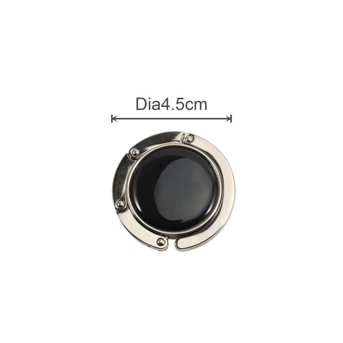 A round, foldable desk hook in shiny silver with a black centre, measuring 4.5 cm in diameter.
