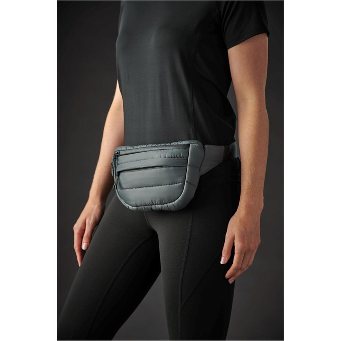 A quilted grey waist bag is worn at the waist, featuring a zippered pocket and padded design.