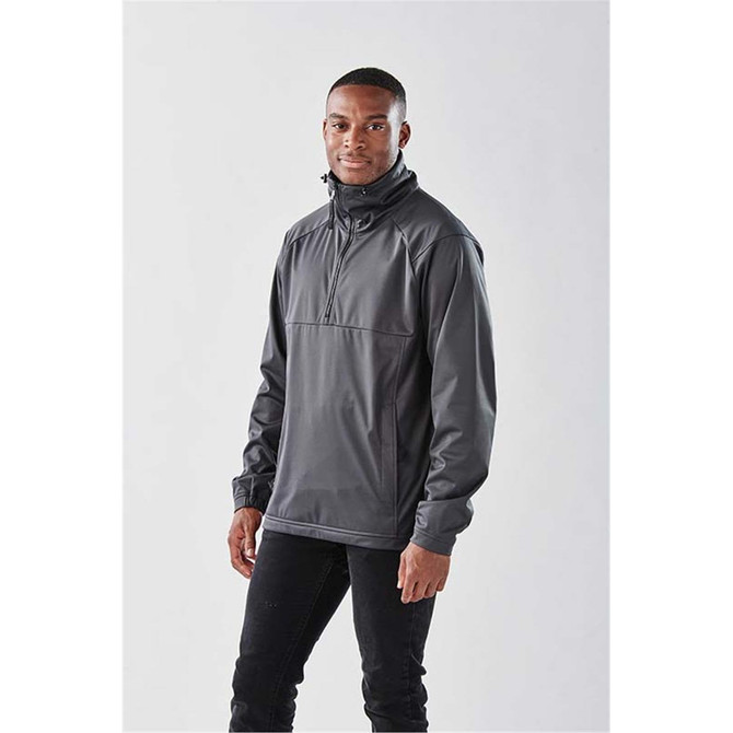 A dark grey men's anorak jacket with a high collar, featuring a logo, displayed on a model against a neutral background.