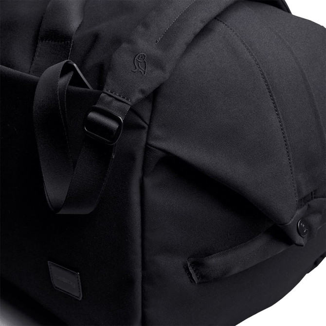 A black duffel bag featuring adjustable straps and a sleek design, with a logo on the side.