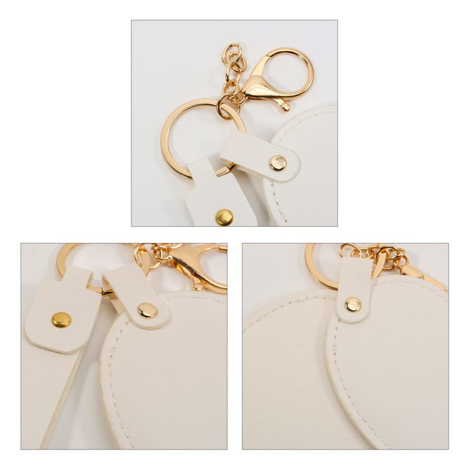 A heart-shaped compact mirror in white with a keychain attachment and gold accents. Features a clasp and loop.