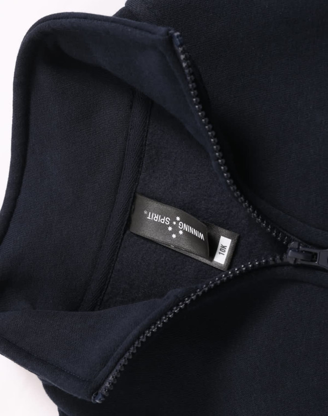 A navy 1/2 zip collar fleecy sweat with a smooth interior and a tag, featuring a logo.