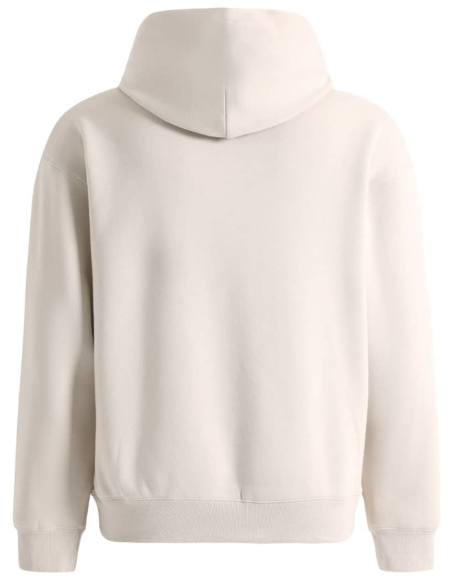 A unisex premium fleece oversized hoodie in a soft cream colour, featuring a large hood and a relaxed fit.
