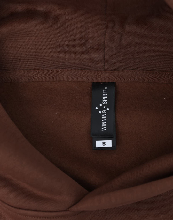 A brown unisex oversized hoodie with a tag displaying size information and a logo.