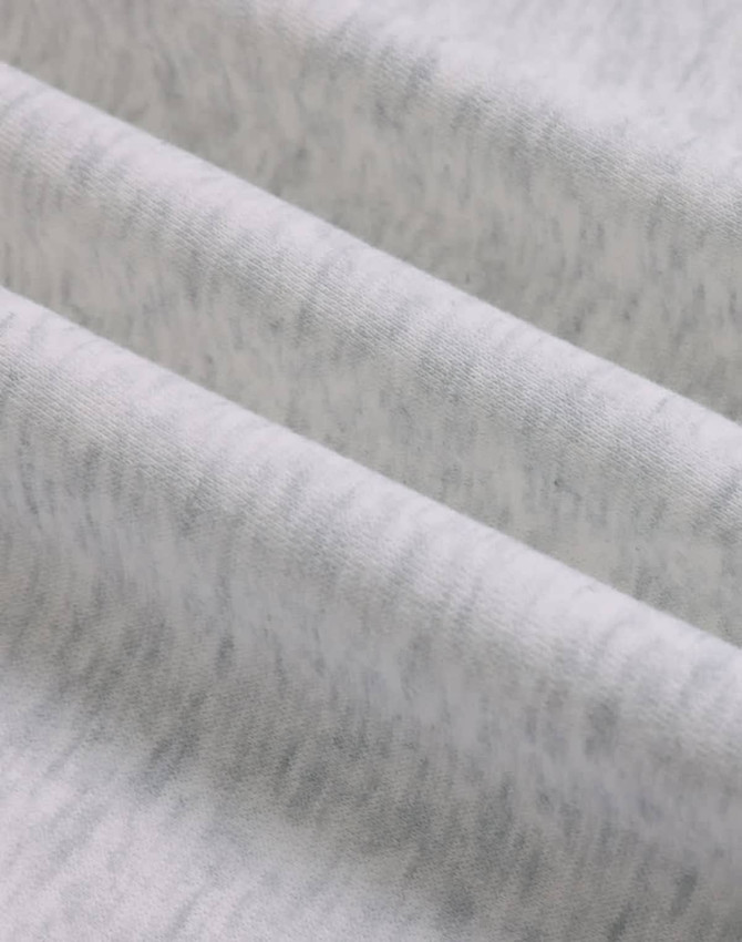 A close-up of soft, grey fabric showing a textured, fleece surface with subtle variations.