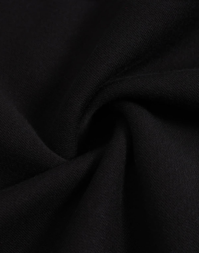 A close-up view of black fleece fabric, showcasing its soft texture and smooth finish.