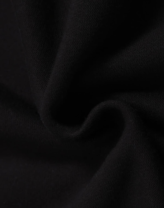 A close-up of black fleece fabric, showcasing its soft texture and smooth finish, with a logo present.