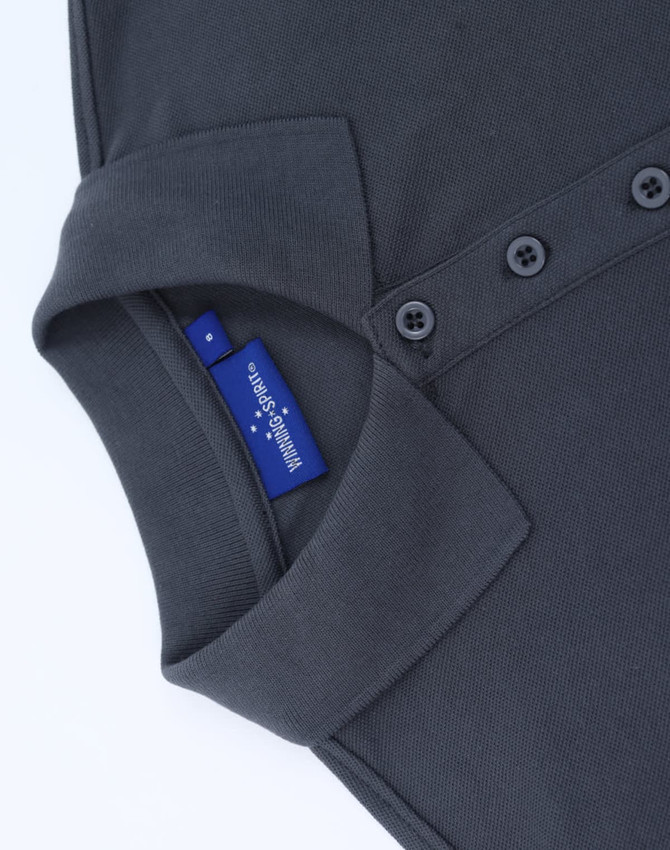 A dark grey ladies' classic cotton/poly pique short sleeve polo featuring a collar and button detail with a tag.