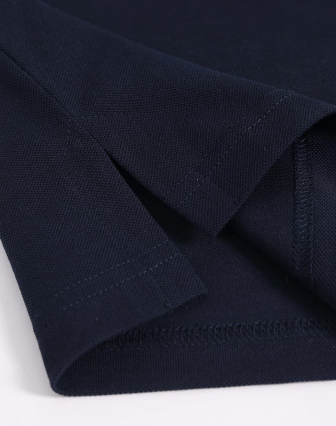 A navy blue men's ultrafine cotton pique polo, featuring a close-up view of the fabric and seam details.
