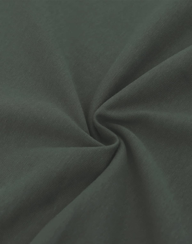 A close-up of a dark green, heavy cotton fabric displaying a smooth texture and subtle sheen.
