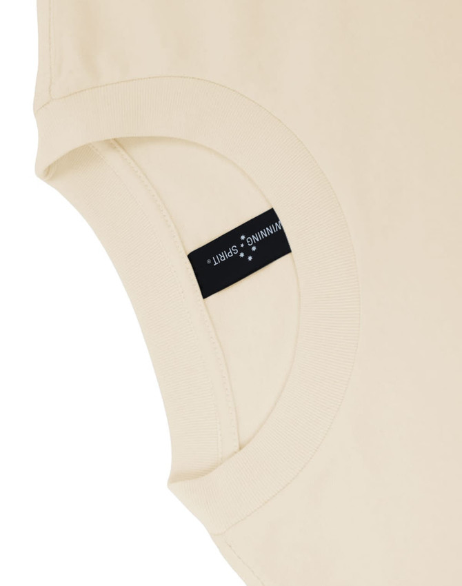 A beige unisex heavy cotton oversized tee featuring a label on the sleeve.