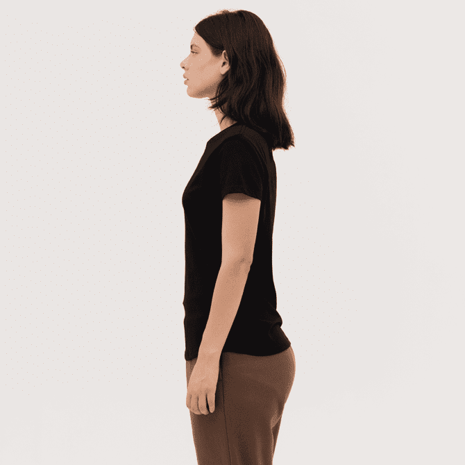A women's essential tee in black, featuring a fitted design and short sleeves, displayed on a model from the side.