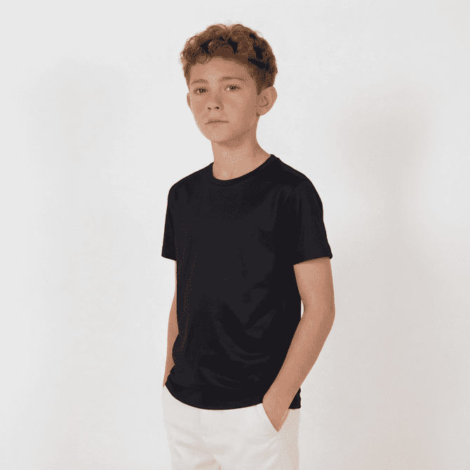 A youth black T-shirt with a simple design, worn by a young boy standing with his hands in his pockets.