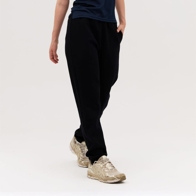 Black track pants with side pockets, worn by a person in gold sneakers against a plain background.