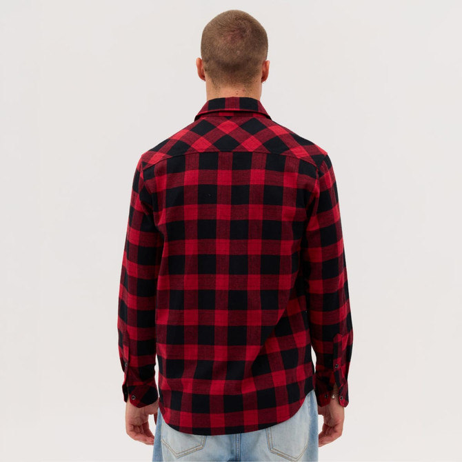 A man is wearing a red and black plaid long sleeve flannel shirt, viewed from the back. The shirt has a collar and buttons.
