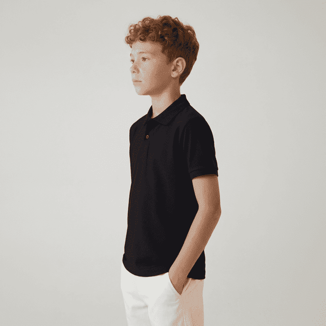 A youth polo shirt in navy blue, featuring a collar and short sleeves, worn by a child standing sideways.