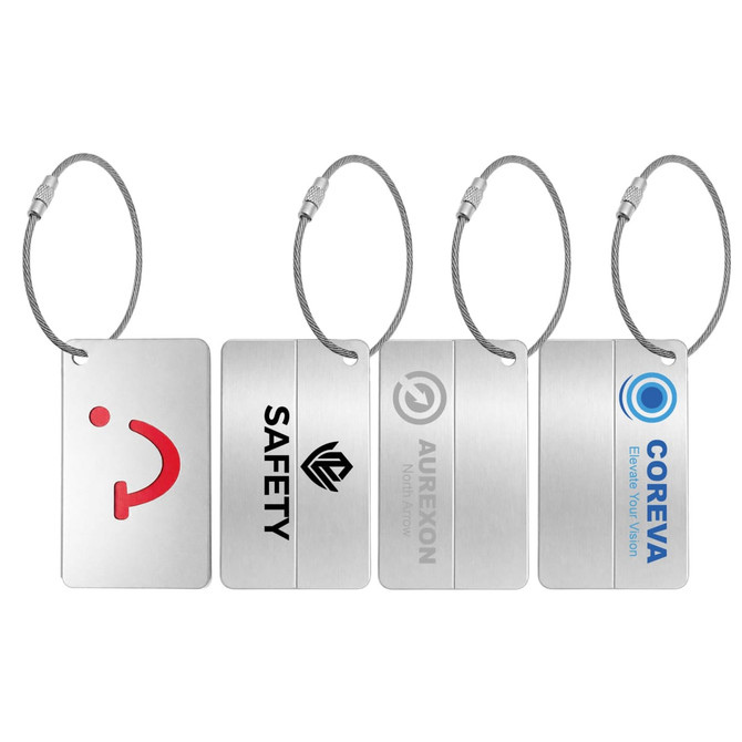 Four metal luggage tags with silver finishes, featuring various shapes and logos, attached to wire loops.