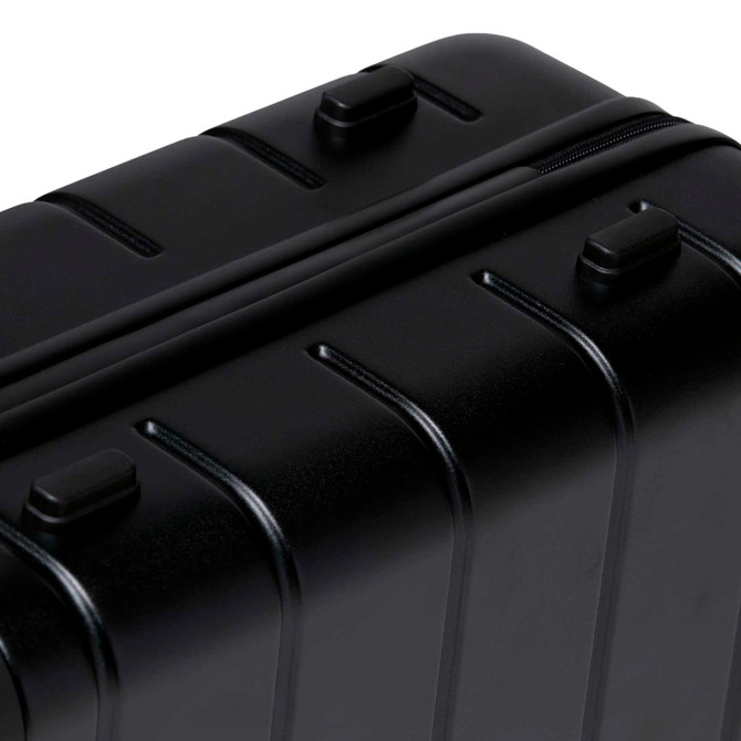 A black hardcase trolley with ridged design, featuring multiple zippers and handles.