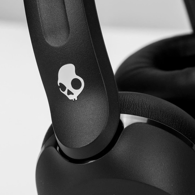 Wireless headphones in black, featuring a distinctive logo, with padded ear cushions and an adjustable headband.