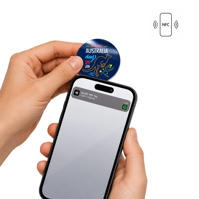 A hand holds a blue NFC acrylic fridge magnet near a smartphone, which displays a notification.